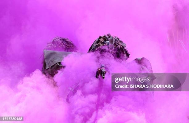 Sri Lankan Air Force troops walk through coloured smoke as they display their commando skills during a passing out ceremony of 329 men and officers...