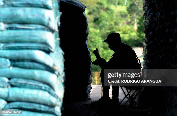 Colombian soldier cleans his rifle in a post on a bridge over the Guaviare river, on the outskirts of the San Jose del Guaviare in southeastern...