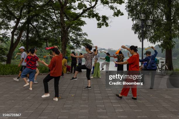 Women exercise next to Hoan Kiem Lake in Hanoi, Vietnam, on Thursday, July 20, 2023. After reducing rates four times this year, the State Bank of...