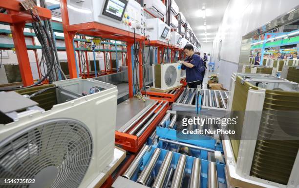 Workers make home air conditioners at a New Energy company production workshop in Anqing City, Anhui Province, China, July 21, 2023.