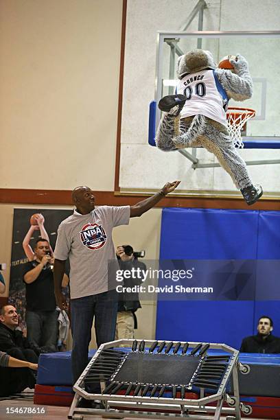 Legend Clyde Drexler assists Minnesota Timberwolves mascot Crunch with a dunk at the dedication of a refurbished basketball court during NBA Canada...