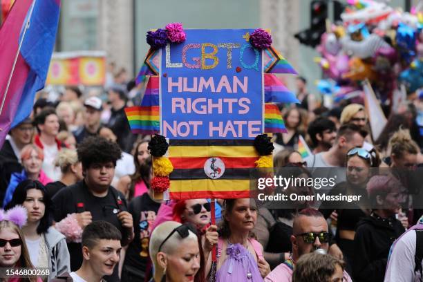 Participant holds a banner among the marchers during the annual Christopher Street Day parade on July 22, 2023 in Berlin, Germany. CSD Berlin is...