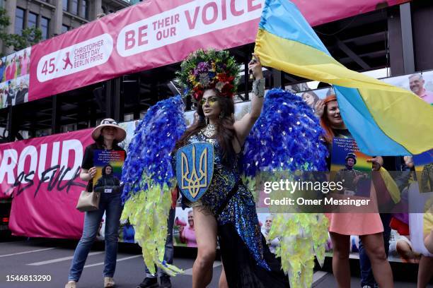 Costumed participant holds a shield and waves the flag of Ukraine during the annual Christopher Street Day parade on July 22, 2023 in Berlin,...