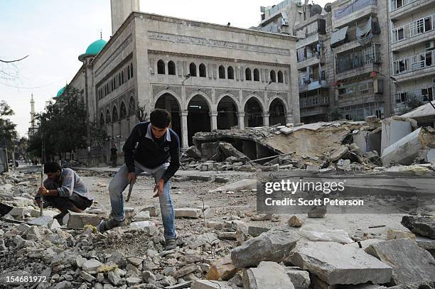 Two Syrian men search for remains of their father killed in a mosque blast, as the intense human and material cost grows from three months of intense...