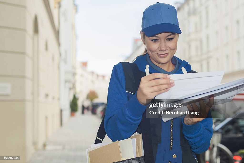 Female postal worker looking through mail