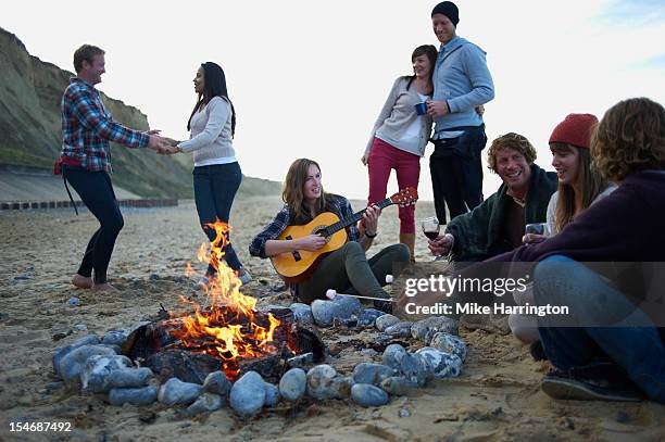 group of friends at beach party. - brand on guitar stock-fotos und bilder