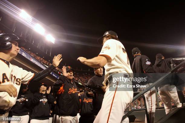 Barry Zito of the San Francisco Giants high fives his teammates in the dugout after being relieved by Tim Lincecum in the sixth inning against the...