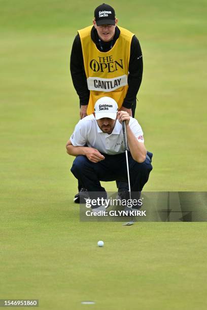 Golfer Patrick Cantlay talks to his caddie Joe LaCava as he lines up a putt on the 18th green on day three of the 151st British Open Golf...