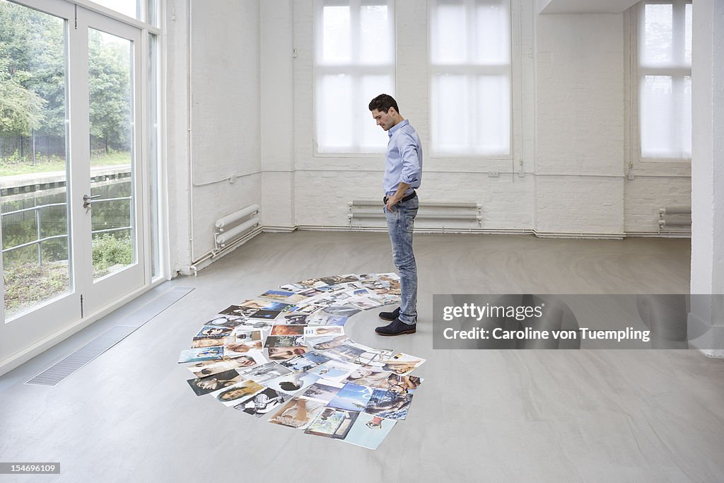 Young professional studying tearsheets on floor