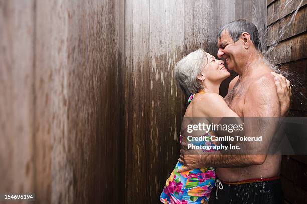 elderly couple taking a shower together - halbbekleidet stock-fotos und bilder