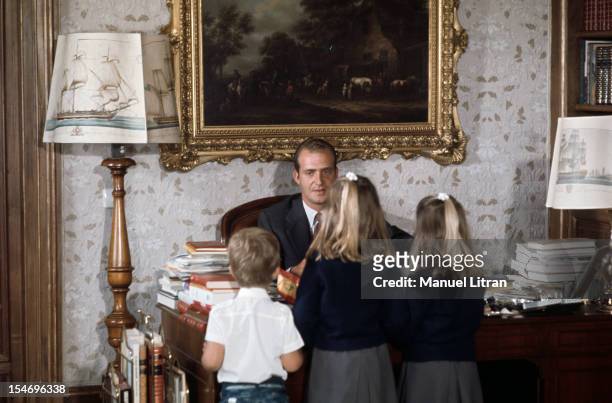 Madrid, July 1971, at the Zarzuela Palace, the three children of Prince Juan Carlos of Spain here, sitting behind his desk, stand back, facing their...