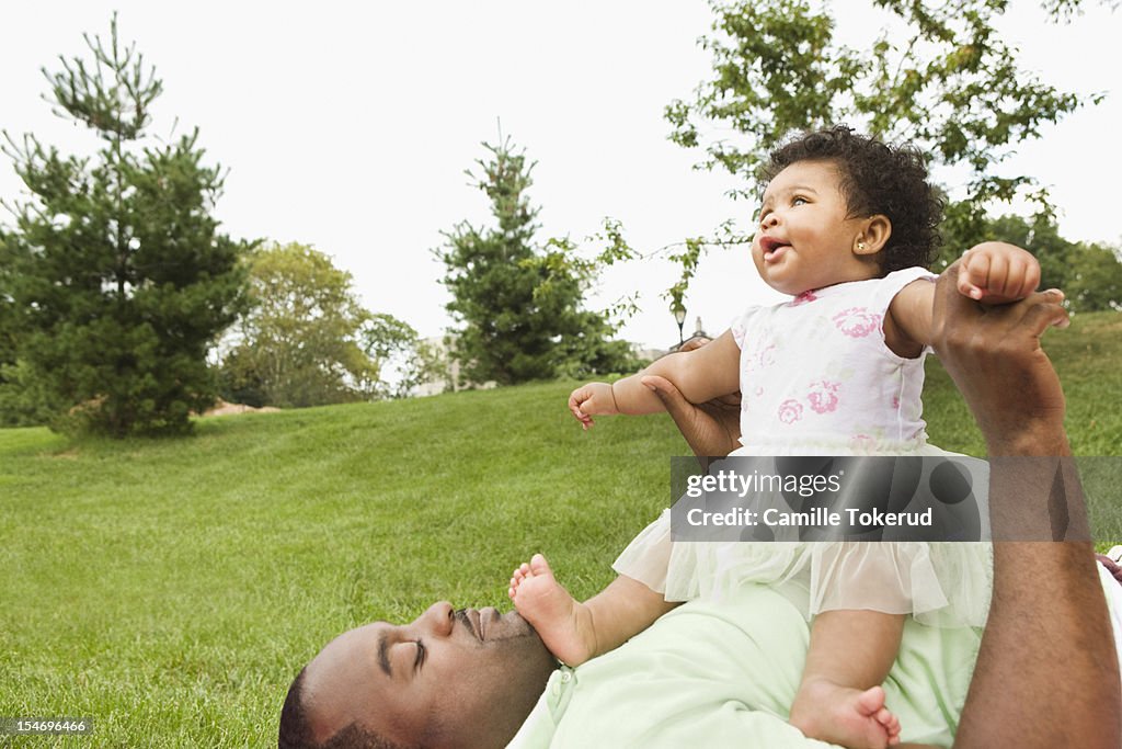 Father and baby daughter playing outdoors