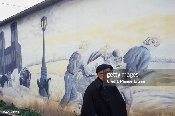 December 1985: Abbe Pierre celebrates Christmas with the Emmaus community: here, the abbot walking along a mural representing the ragpickers of...