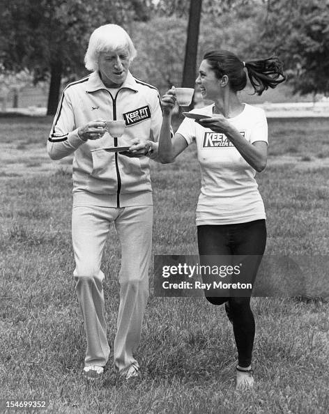 English Dj And Television Presenter Jimmy Savile Holding A News Photo English Dj And Television Presenter Jimmy Savile Holding A News Photo