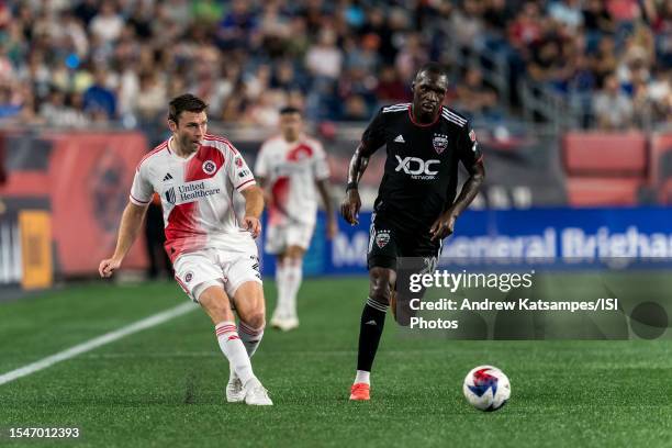 Dave Romney of New England Revolution passes the ball as Christian Benteke of D.C.United closes during a game between D.C.United and New England...