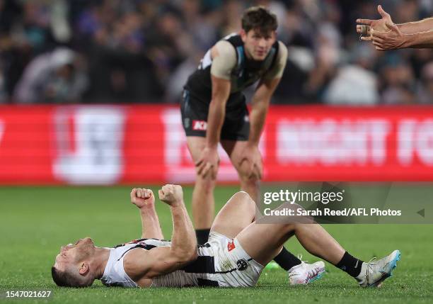 Taylor Adams of the Magpies reacts on the siren in his 200th game with Zak Butters of the Power in the background during the 2023 AFL Round 19 match...