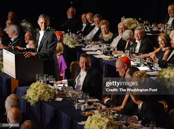 President Barack Obama, left, looks toward his challenger, Mitt Romney, second left, as he makes remarks at the Alfred E. Smith dinner in New York on...