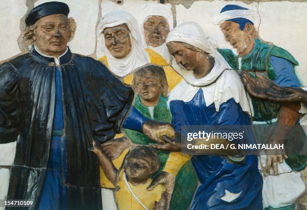 Feed the hungry, scene from Seven Works of Mercy, 1525-1528, by Santi Buglioni , glazed terracotta frieze, Ceppo Hospital, Pistoia, Tuscany. Detail....