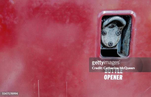 slot for bottle opener on antique red metal soda vending machine - vending machine stock-fotos und bilder