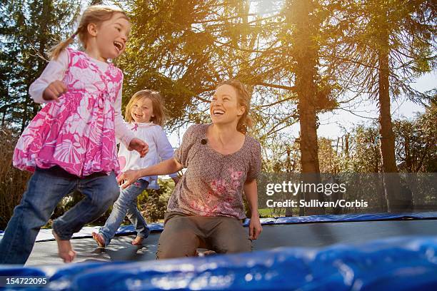 smiling woman playing with daughters (4-5) - andreas pollok stock-fotos und bilder