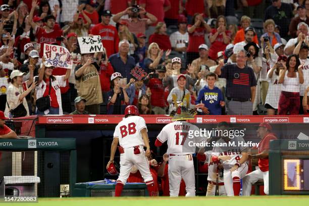 Shohei Ohtani of the Los Angeles Angels is congratulated at the dugout after hitting a solo homerun during the ninth inning of a game against the...
