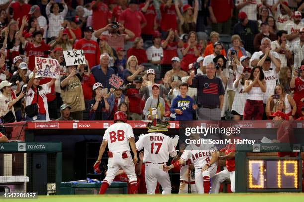 Shohei Ohtani of the Los Angeles Angels is congratulated at the dugout after hitting a solo homerun during the ninth inning of a game against the...