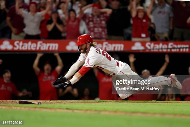 Trey Cabbage scores on a single hit by Taylor Ward of the Los Angeles Angels during the tenth inning of a game against the Houston Astros at Angel...