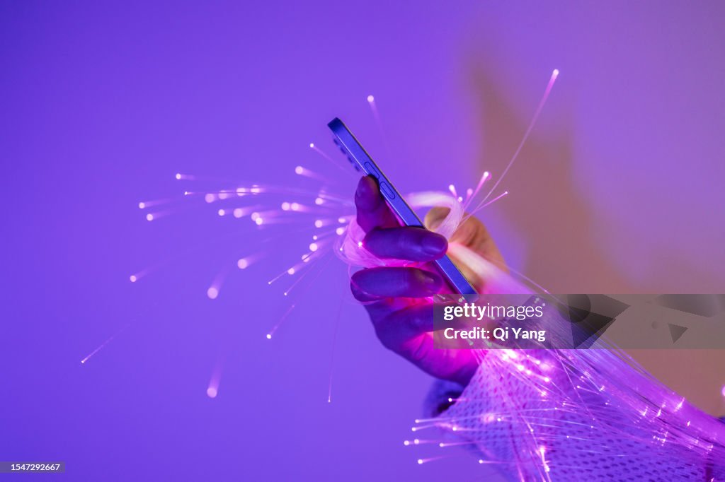 Close-up of holding smartphone and fiber optic