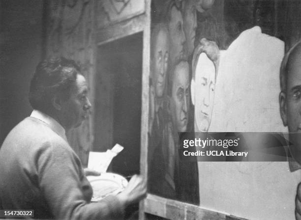 View of Mexican artist and painter Diego Rivera as he works on a large mural at the New Workers School, New York, New York, 1930s.