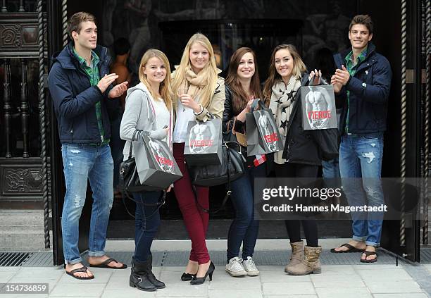 Young women pose for photographs with male models outside Abercrombie & Fitch during the opening of Abercrombie & Fitch Munich flagship store on...