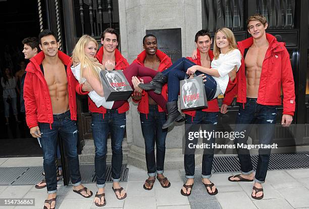 Young women pose for photographs with male models outside Abercrombie & Fitch during the opening of Abercrombie & Fitch Munich flagship store on...