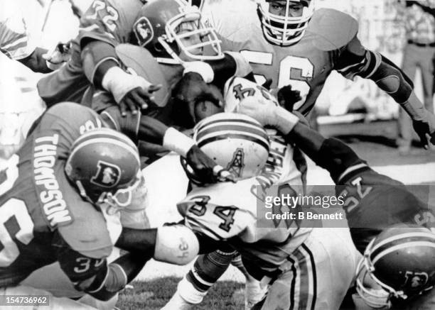 Earl Campbell of the Houston Oilers is tackled on the goalline by Rulon Jones, Larry Evans, Don Latimer, Steve Foley and Billy Thompson of the Denver...