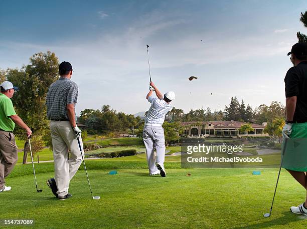 foursome teeing off - golf clubhouse stockfoto's en -beelden