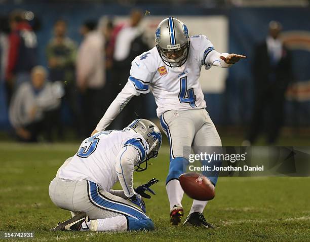 Jason Hanson of the Detroit Lions kicks an extra point out of the hold of Nick Harris against the Chicago Bears at Soldier Field on October 22, 2012...