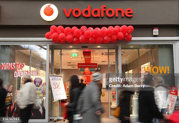 Shoppers pass a Vodafone shop on October 25, 2012 in Berlin, Germany. Retail business is the third-biggest economic sector in Germany, and consumer...