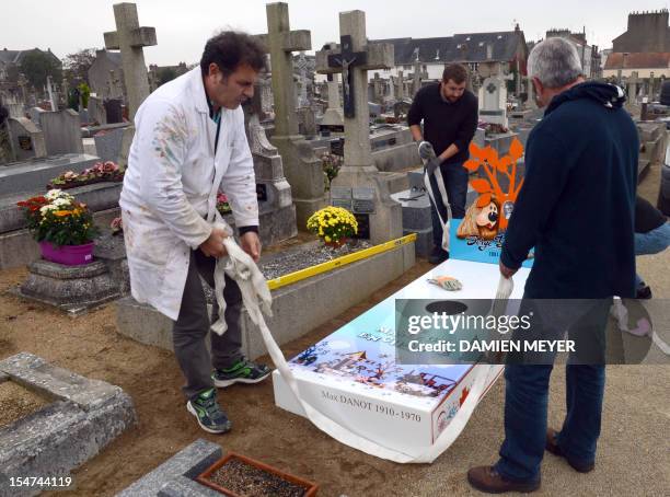 Workers install the "iron grave" of the family of Serge Danot who died in 1990 and was the creator of the French television programme "The Magic...