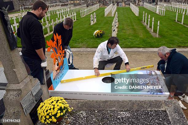 Workers install the "iron grave" of the family of Serge Danot who died in 1990 and was the creator of the French television programme "The Magic...