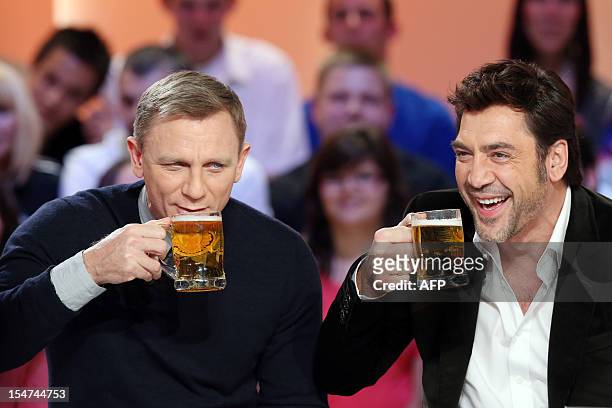 British actor Daniel Craig and Spanish actor Javier Bardem, starring in the new James Bond film "Skyfall", drink beer glasses as they take part in...