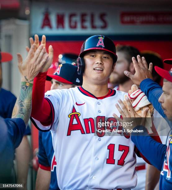 Anaheim, CA Angels starting pitcher and two-way player Shohei Ohtani is congratulated by teammates after scoring on Angels center fielder Mickey...