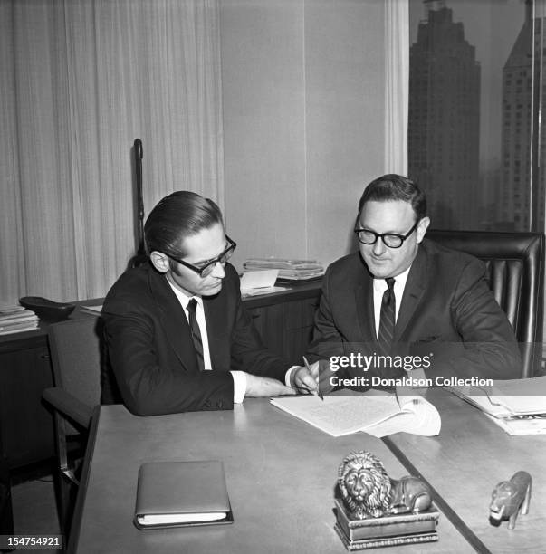 Jazz pianist and composer Bill Evans signs a record deal with MGM records executive Mr. Wassiter on February 27, 1967 in New York, New York.