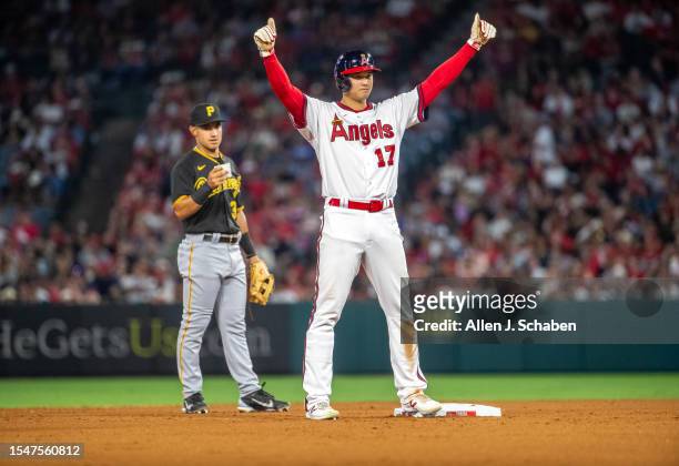 EAnaheim, CA Pirates second baseman Nick Gonzales, left, watches as Angels starting pitcher and two-way player Shohei Ohtani raises his arms at...