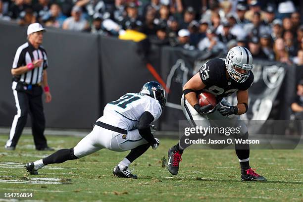 Tight end Brandon Myers of the Oakland Raiders is tackled by cornerback Aaron Ross of the Jacksonville Jaguars in the third quarter at O.co Coliseum...