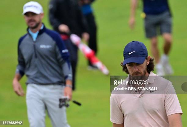 Golfer Brian Harman and England's Tommy Fleetwood walk up the play on the 11th green on day three of the 151st British Open Golf Championship at...