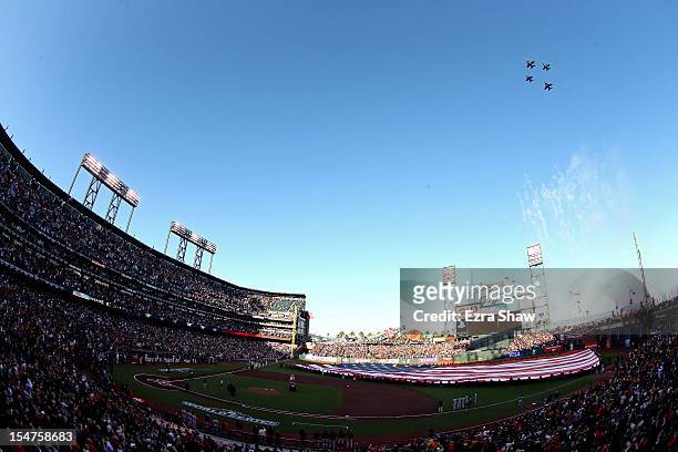 General view of Jets performing a flyover as a giant American Flag is stretched across the outfield for the performance of the National Anthem prior...