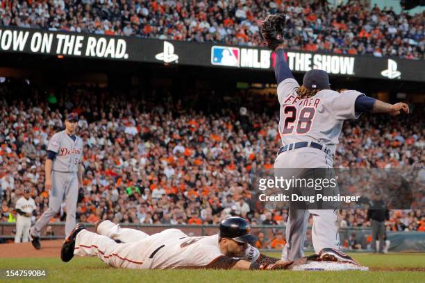 Marco Scutaro of the San Francisco Giants head first slides as he is forced out at first base by Prince Fielder of the Detroit Tigers in the third...