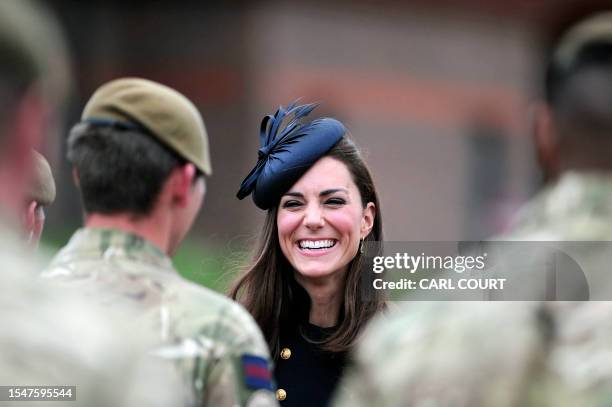 Kate, The Duchess of Cambridge speaks with soldiers in Victoria Barracks in Windsor, west of London, on June 25 during a medal parade for the 1st...