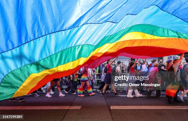 Participants hold a big pride rainbow flag during the annual Christopher Street Day parade on July 22, 2023 in Berlin, Germany. CSD Berlin is among...