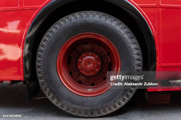 an old red wheel with a black tire of a heavy machine. a part, a working part of a tractor or truck. a wheel of heavy machinery in close-up, in the countryside. non-urban scene. work on the construction site. the concept of agriculture, industry. - non motorised vehicle stock pictures, royalty-free photos & images