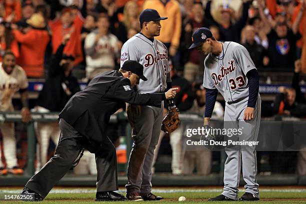 Home plate umpire Dan Iassogna signals fair ball as Miguel Cabrera and Drew Smyly of the Detroit Tigers look on on a ball bunted by Gregor Blanco of...