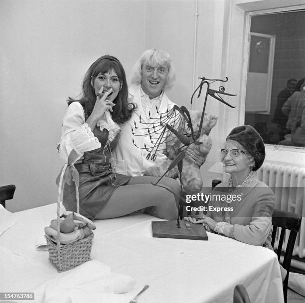 English dj and television presenter Jimmy Savile with English actress Anita Harris and his mother Agnes, 5th November 1968.